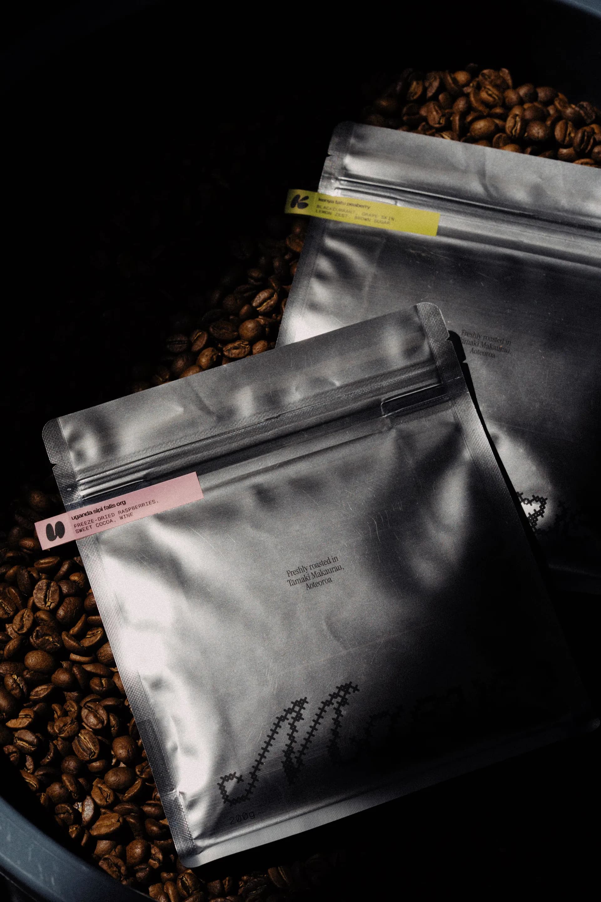 Maeve coffee bags resting on freshly roasted beans
